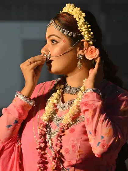 A profile shot of the Radha look, highlighting the traditional 'nath' and floral hair accessories.
