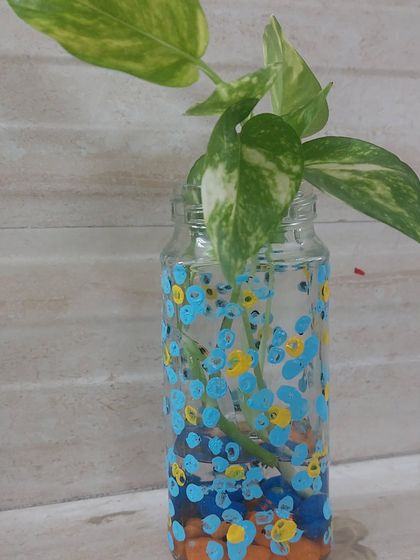 A simple glass jar is transformed into a beautiful vase with a bit of paint. This upcycling project is not only creative but also adds a touch of green to your home.