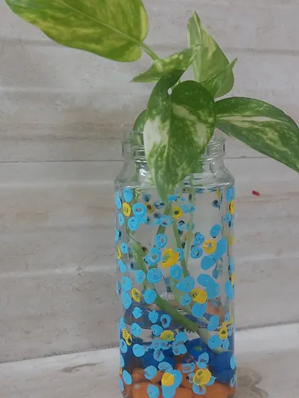 A simple glass jar is transformed into a beautiful vase with a bit of paint. This upcycling project is not only creative but also adds a touch of green to your home.