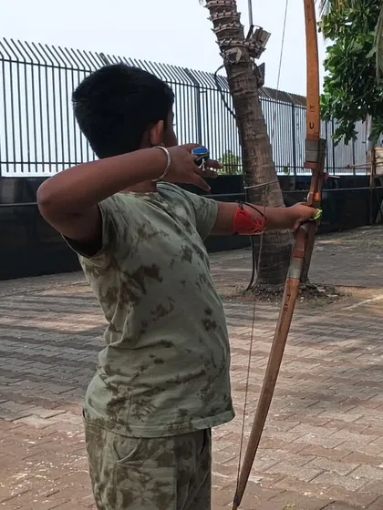 A young archer takes his shot at the outdoor range. We teach students to adapt to different environmental conditions.