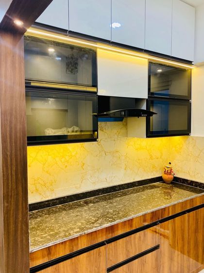 This kitchen combines wood-finish lower cabinets with white upper cabinets for a classic yet modern look. The black glass-fronted cabinets add a bold contrast.