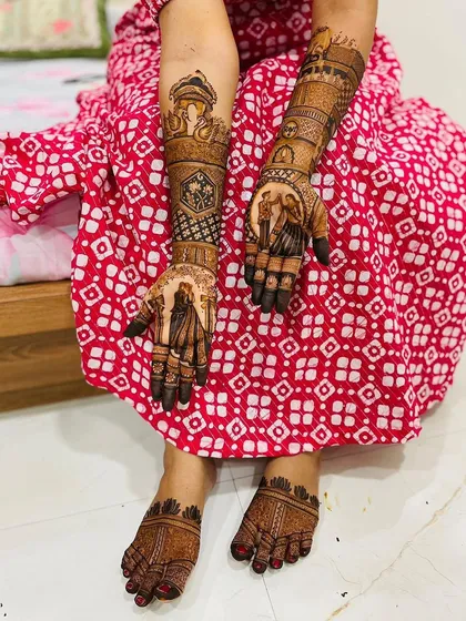 A full view of a bride's complete mehndi look, with coordinated designs on her hands and feet.