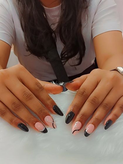 Black is not just a color, it’s an attitude. This chic set features a mix of solid black nails and nude accent nails with delicate, abstract black swirls.