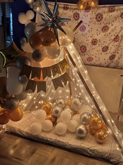 Let's get the bachelorette party started with a fun 'Bride to Be' cabana. This cozy tent is decorated with fairy lights and a stylish gold, silver, and white balloon arrangement, creating the perfect spot for the bride squad to celebrate.
