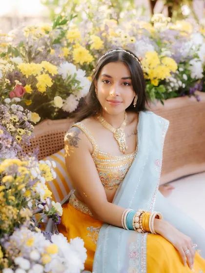 This sun-kissed floral look is perfect for a Haldi or Mehendi. Surrounded by flowers, the bride's makeup is fresh and dewy, with soft, natural tones that complement the bright and cheerful setting.