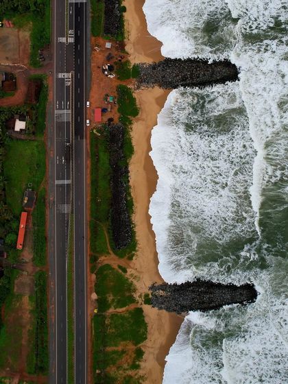 An overhead drone shot of the sea wall and waves crashing on Maravanthe beach.