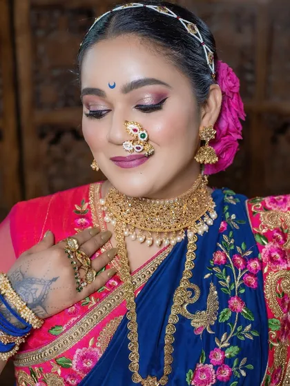 The soft glam makeup complements the rich embroidery of the saree, creating a harmonious and beautiful look.