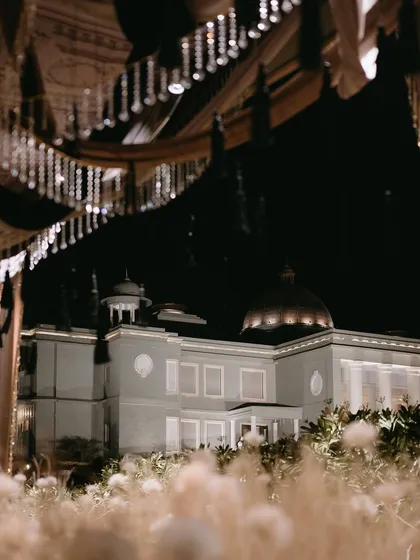A view of the Raffles Udaipur palace at night, framed by the dreamy, white-themed Sangeet decor.