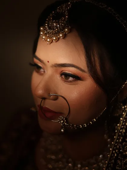 A dramatic, low-key portrait focusing on the bride's eyes and traditional nath. This shows the artistic side of my bridal photography.