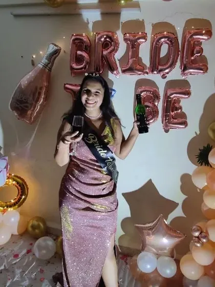 The bride-to-be celebrating with a glass of wine, wearing her sash. Our decor sets the perfect mood for a fun and memorable party with friends.
