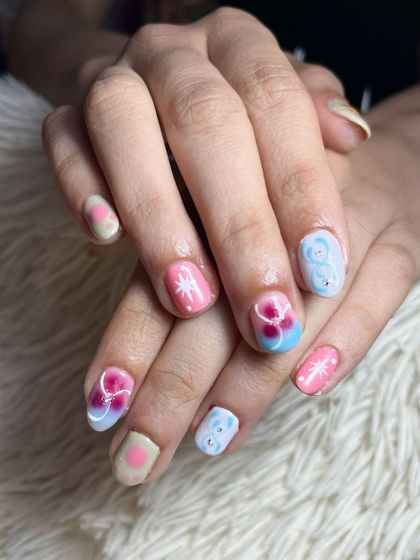 Nails that speak louder than words. This playful and colorful design includes hand-painted flowers and other cute patterns for a fun and whimsical look.