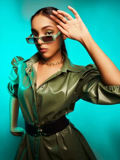 This olive green leather-look dress is a statement piece for the fashion-forward individual. Paired with a thick belt and modern sunglasses, it creates a powerful and edgy silhouette.