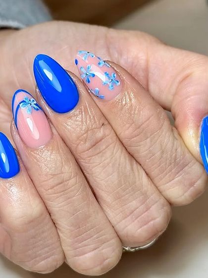 Blue skies and flower vibes right at your fingertips. This elegant set features a bold, glossy blue base with accent nails showcasing delicate, sheer blue flowers.