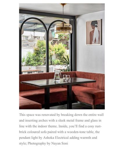 The press clipping details the renovation of this cozy dining space, where I inserted arches and paired a rust-colored sofa with a pendant light to create a warm and stylish nook.