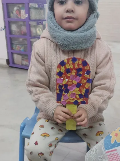 This little girl proudly displays her colorful ice cream craft made from paper cutouts. This project is great for learning shapes, colors, and practicing pasting skills.