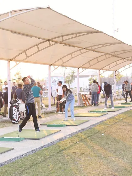 A wide shot of our covered bays, filled with golfers enjoying a weekend session. The atmosphere is always lively and welcoming.