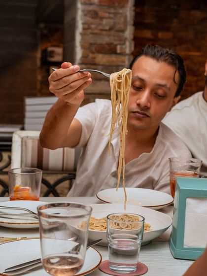 A guest savors a forkful of our authentic, hand-made pasta.