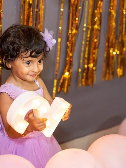 For this little one's birthday photoshoot, we created a magical setting with soft pink balloons and shimmering gold streamers. I love capturing these milestone portraits, focusing on the birthday girl's bright eyes and happy smile as she celebrates her special day.