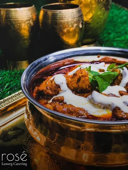A bowl of rich, creamy butter chicken, a classic North Indian dish beloved by all. For over 15 years, we have dedicated ourselves to refining our recipes to add a touch of magic to your occasions.