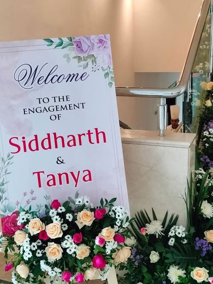 A personalized welcome sign for an engagement, beautifully integrated with the floral decor lining the staircase.