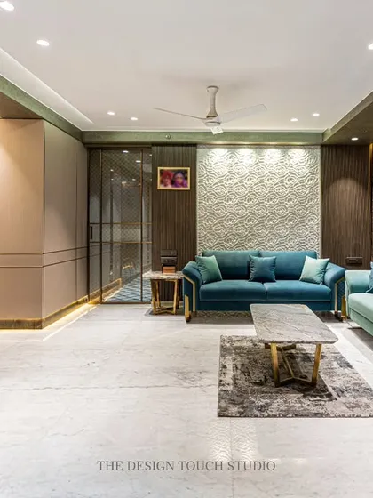 This living and dining space showcases a serene palette of pastel teal and beige. We used velvet upholstery and gold-detailed furniture to create a look of minimal luxury, while the textured wall panels add depth and character.
