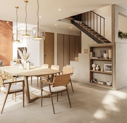 The living and dining space in our Kolgaon Masterplan has an open, fresh, and light feel. A central staircase bridges furniture and architecture, while a feature brick wall flows from the outside in, connecting the interior to the building's material palette.