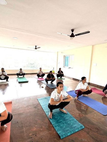 The class practices Malasana, or Garland Pose, a deep squat that is excellent for hip-opening and improving digestion. It's a foundational pose we return to often.