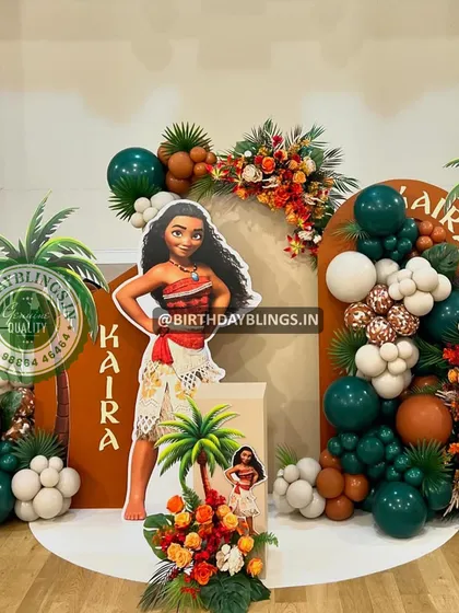 A lush and tropical Moana-themed party, perfect for an adventurous child. This setup features rich, autumnal colors, palm tree props, and a life-sized Moana cutout.