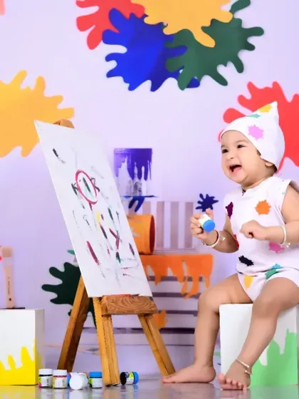 Another shot from the little artist theme, this time with the baby laughing while holding a paintbrush. It captures a moment of pure joy.