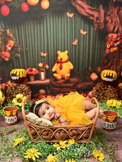 A sweet newborn girl in a Winnie the Pooh inspired setting. Lying peacefully in a basket, this portrait captures the serene beauty of the first few weeks of life.