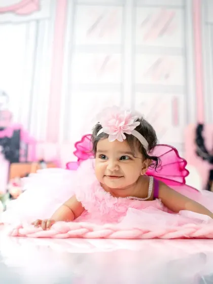 A sweet tummy-time pose for this 6-month-old. The pink fairy wings and floral headband add a touch of whimsy to this Barbie-inspired milestone shoot.