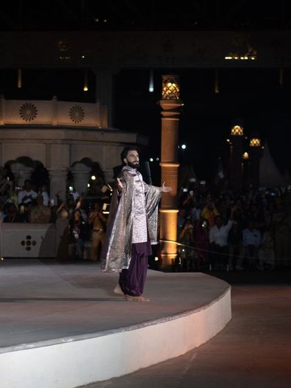 A wide shot of Ranveer Singh on the expansive stage in Varanasi, giving a sense of the scale and grandeur of Manish Malhotra's outdoor fashion show.
