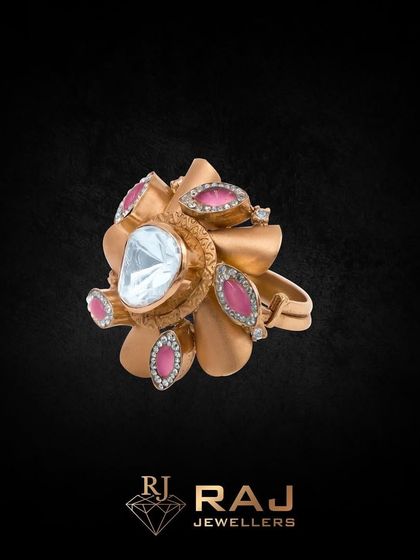 A statement floral ring designed to capture attention. This piece features a large central polki stone surrounded by petals of matte gold and pink gemstones, creating a bold and beautiful accessory.