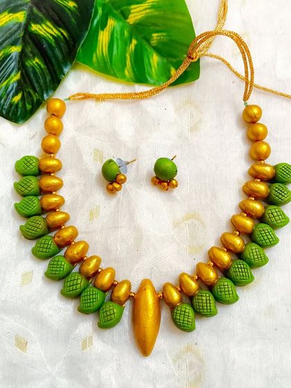 A duplicate image of the green and gold leaf-textured choker, showing its simple elegance.