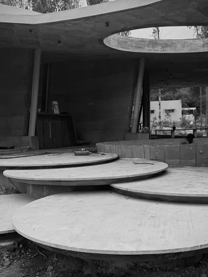 The circular concrete platforms and curved roof of the resort's common area, showcasing the project's unique geometry.