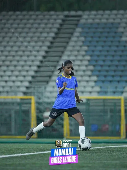 A young female player confidently dribbles the ball during a DPDL Mumbai Girls League match. This action shot showcases the skill and focus being developed in the next generation of women's football.