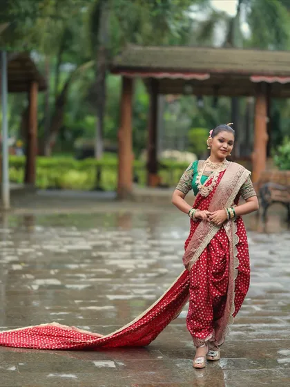 The elegance of the red Nauvari with its long trail, captured in a beautiful outdoor setting.