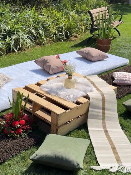 A cozy little picnic spot for two. This setup features a low pallet table, soft rugs, and comfortable cushions, proving that even a small, intimate gathering can be incredibly stylish.