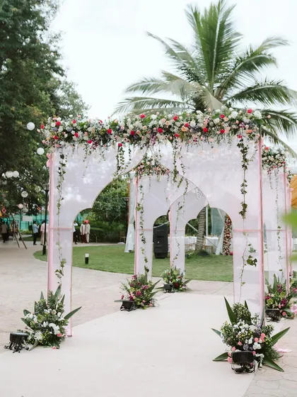 Your wedding journey begins with the first step inside. I designed this elegant entrance with modern arches, sheer drapes, and cascading florals to give guests a breathtaking welcome.