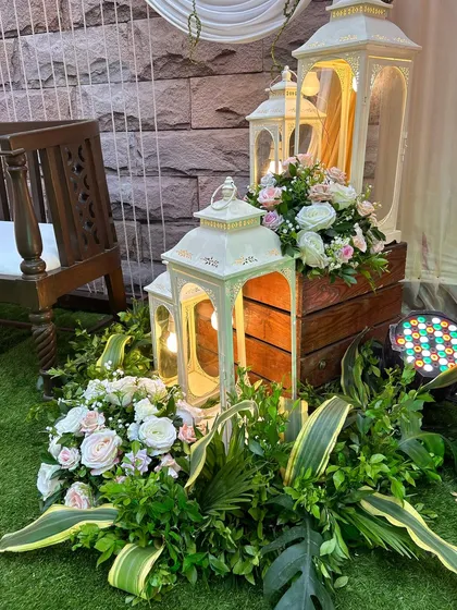 A close-up of the rustic-chic decor, featuring white lanterns and soft floral arrangements. These details add a warm and romantic glow to the evening.