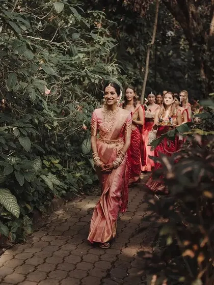 The arrival of the bride is always the most poetic moment. Here, Vidya and her girls walk amidst the rustling leaves and dancing sunlight at the Taj Westend, a bridal entry that perfectly captures the anticipation and joy we love to orchestrate.