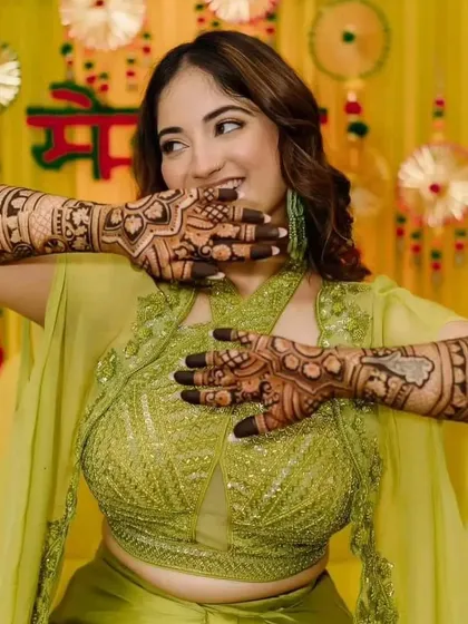 A candid and joyful photo of a bride at her mehendi function, showcasing her beautiful henna.