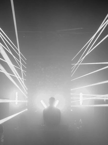 A black and white version of the laser show, emphasizing the raw power and structure of the light design.