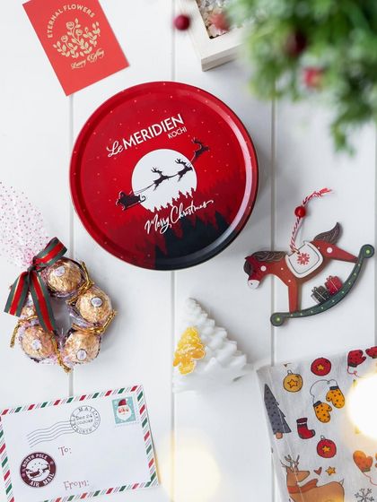 The contents of the 'Winter Wonderland' hamper, including a custom Christmas tin, chocolates, and ornaments, ready to be gifted.