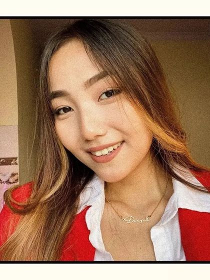 A smiling customer wearing her custom name necklace. This image captures the joy and confidence that comes from wearing a piece of jewelry that is uniquely yours.