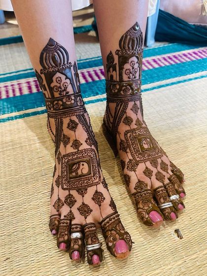 This foot design features charming elephant motifs inside framed boxes, matching the storytelling theme on the bride's hands.