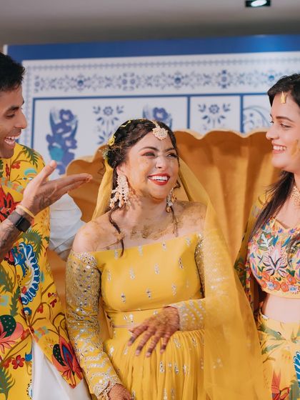 A candid shot of the bride sharing a laugh with her brother, cricketer Surya Kumar Yadav, and his wife during the Haldi.