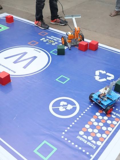 Two robots face off on a competition mat. This shows the exciting, game-based learning approach we use to teach complex robotics concepts.