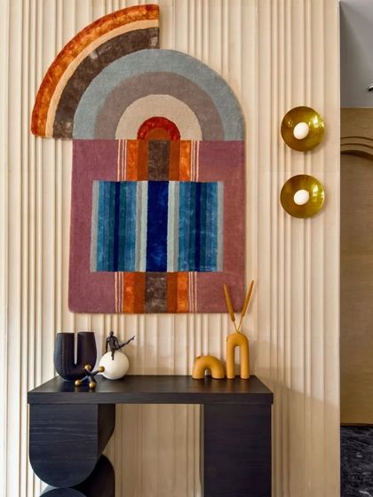 I love playing with color and geometric shapes. This vibrant, bohemian-style wall tapestry adds so much happiness and personality to this corner, especially against the fluted wall panel and paired with modern brass sconces.
