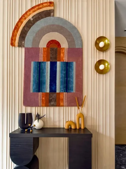 This colorful and abstract wall art brings a burst of happiness to this banquet hall's entryway. Paired with a modern console table and unique decor pieces, it creates a vibrant and welcoming first impression for guests.